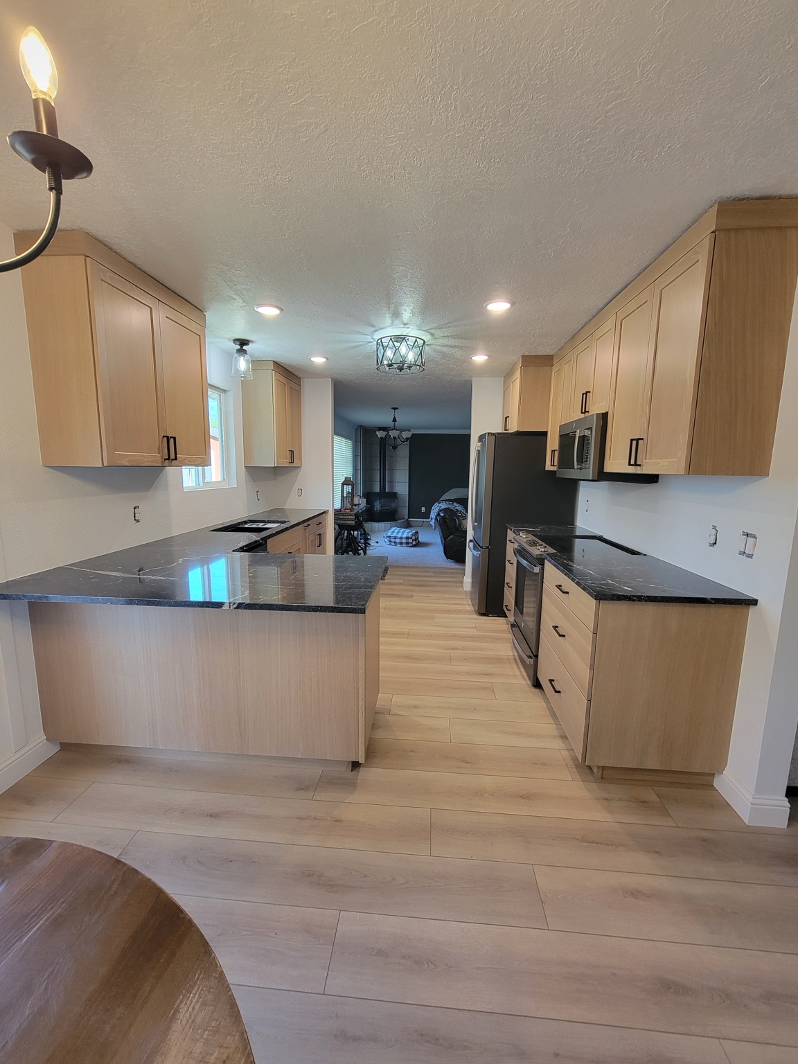 Kitchen with natural wood cabinets and dark countertops