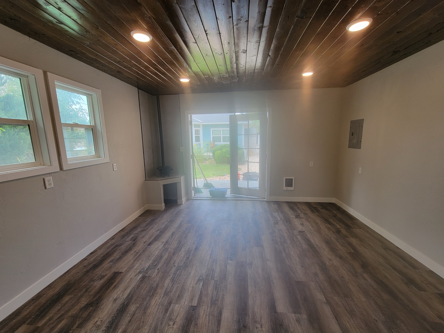 Updated room with wood ceiling, recessed lights, and wood-look flooring