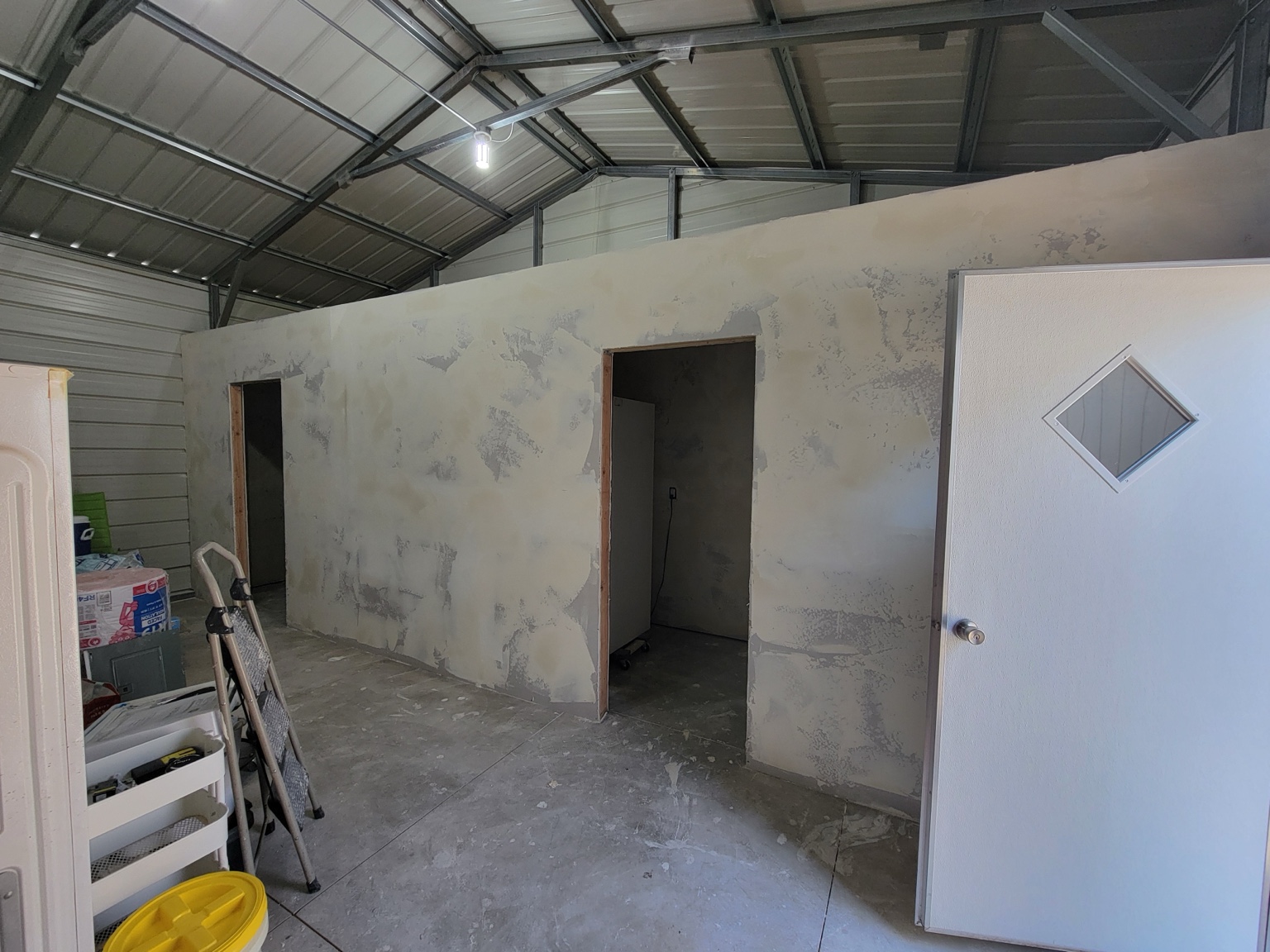 Drywall finishing around door openings inside a metal building
