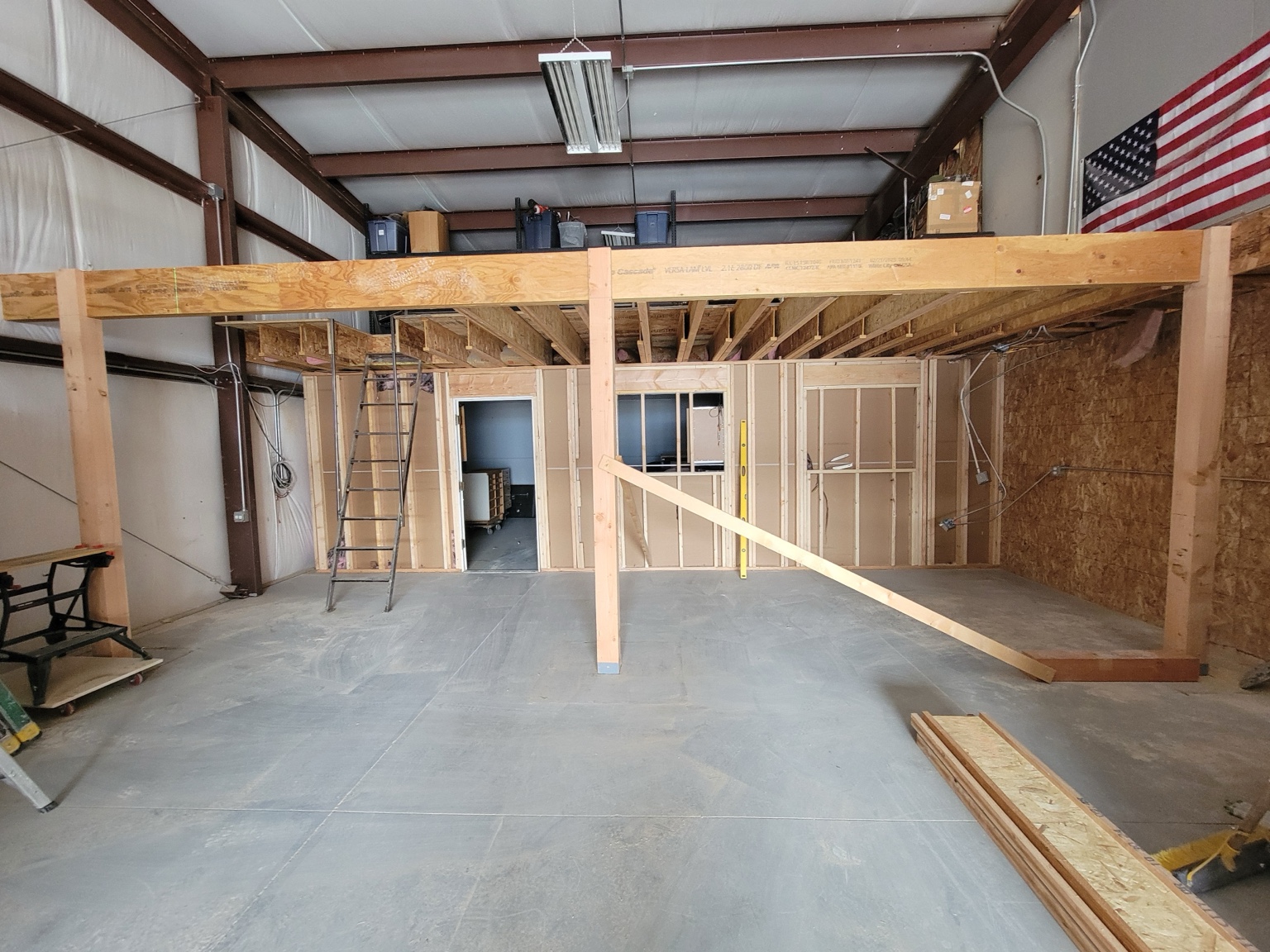Wood posts, beam, and floor framing inside a shop